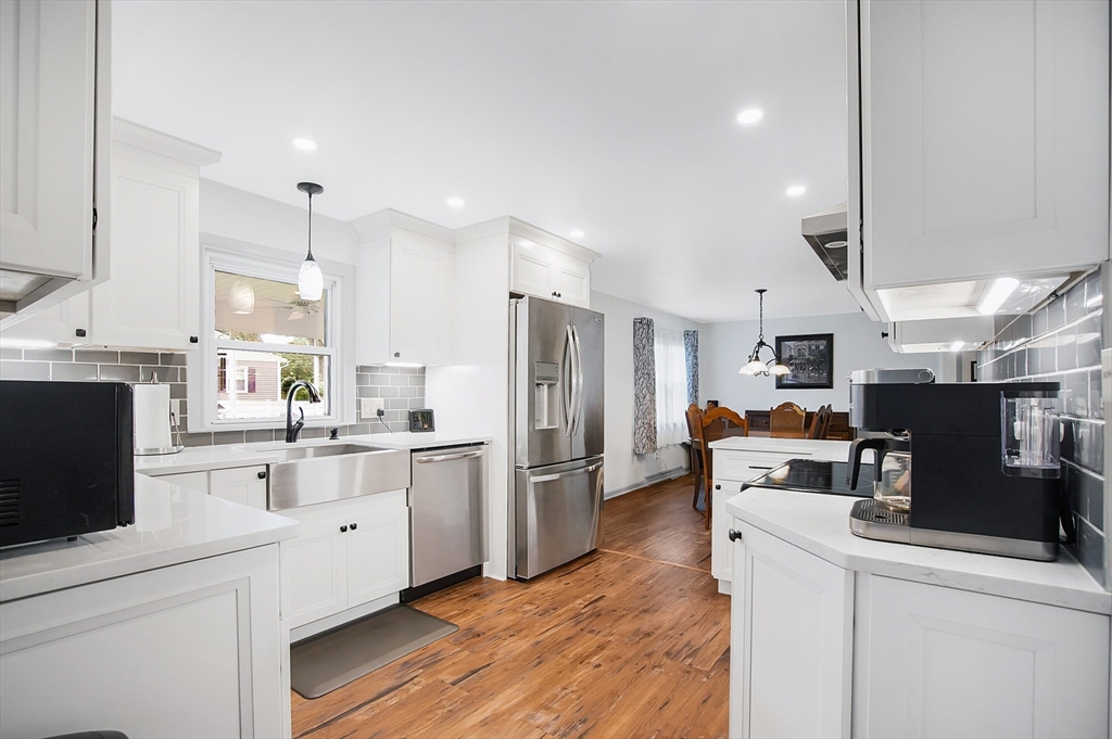 407 Wolf Swamp Road Longmeadow, MA 01106 - Photo 7 of 42 a kitchen with stainless steel appliances kitchen island granite countertop a refrigerator oven a sink dishwasher and white cabinets with wooden floor