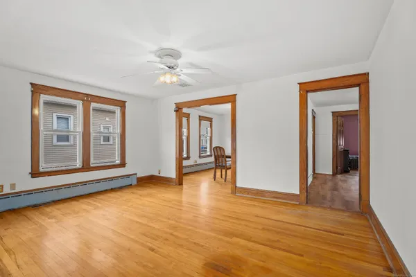 a view of an empty room with window and wooden floor