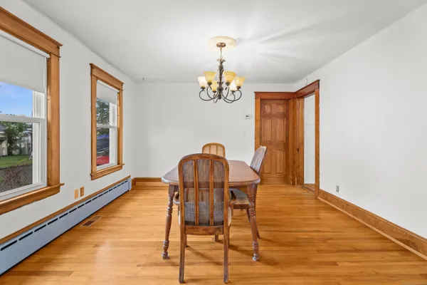 a dining room with furniture a chandelier and wooden floor