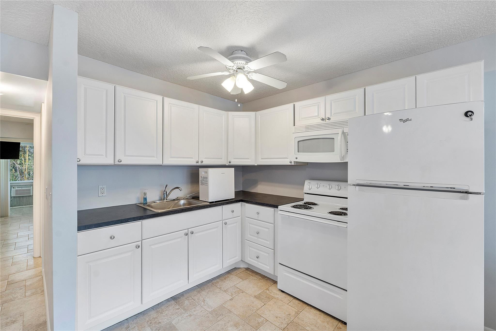 518 Durham, Unit 518 Deerfield Beach, FL 33442 - Photo 6 of 31 a kitchen with white cabinets and white appliances