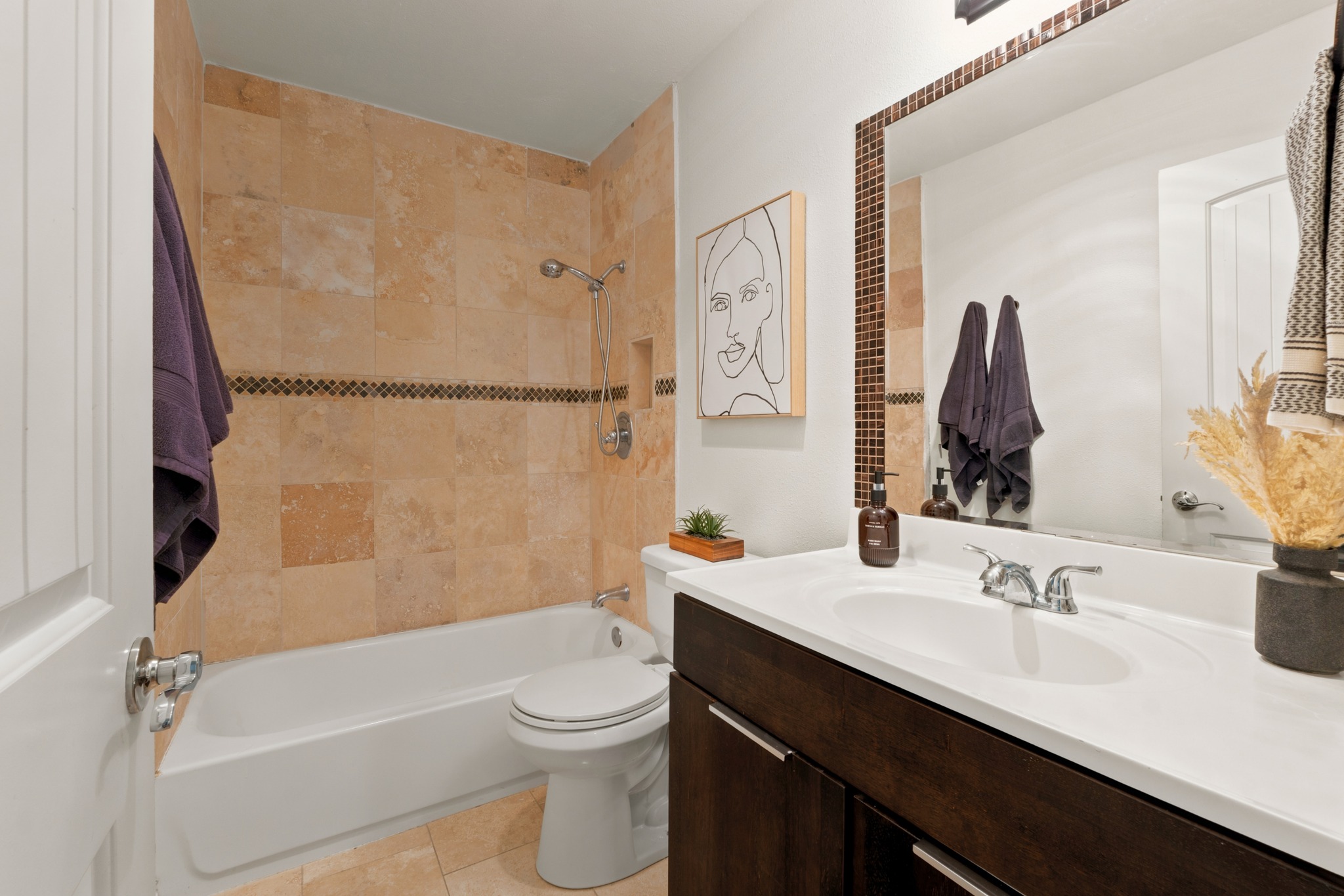 1504 Allen Road, Unit B Austin, TX 78746 - Photo 16 of 24 Tiled walls frame the tub shower combination alongside a modern vanity with integrated sink.