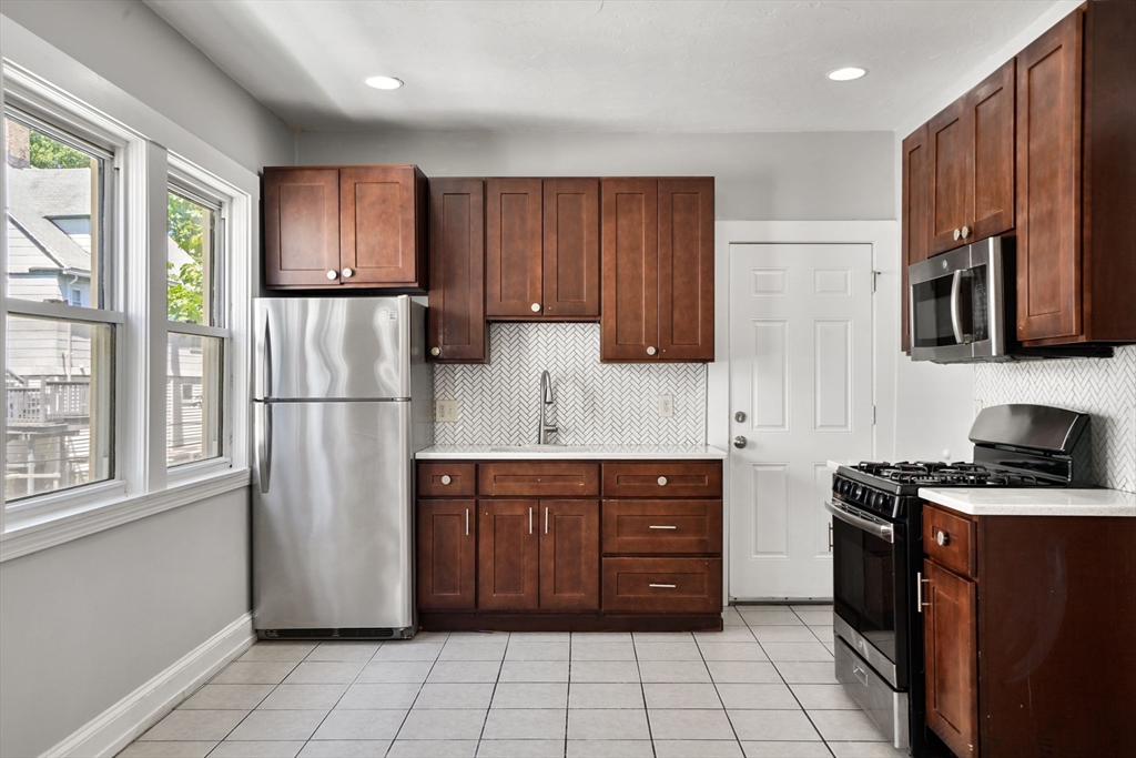 32 Millet Street, Unit 2 Boston, MA 02124 - Photo 1 of 14 a kitchen with stainless steel appliances granite countertop a refrigerator stove and cabinets