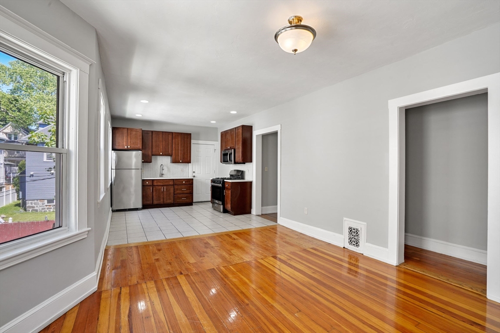 32 Millet Street, Unit 2 Boston, MA 02124 - Photo 3 of 14 a large room with wooden floor and a kitchen