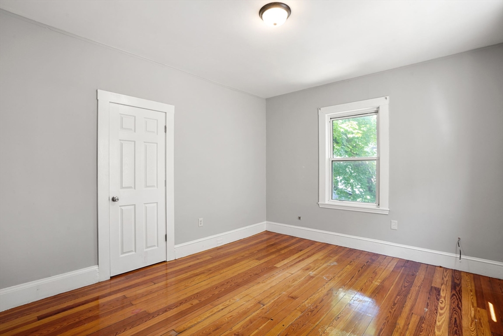 32 Millet Street, Unit 2 Boston, MA 02124 - Photo 9 of 14 an empty room with wooden floor and windows