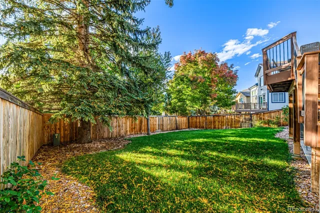 a view of backyard with potted plants and wooden fence