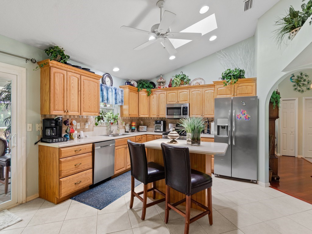 5302 Seminole Road Fort Pierce, FL 34951 - Photo 10 of 36 a kitchen with a table chairs refrigerator and cabinets