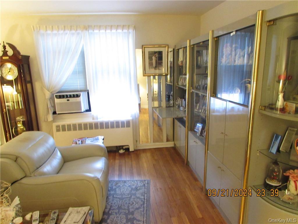 1561 Central Park Avenue, Unit I5 Yonkers, NY 10710 - Photo 4 of 18 Living room featuring cooling unit, radiator, and hardwood / wood-style flooring