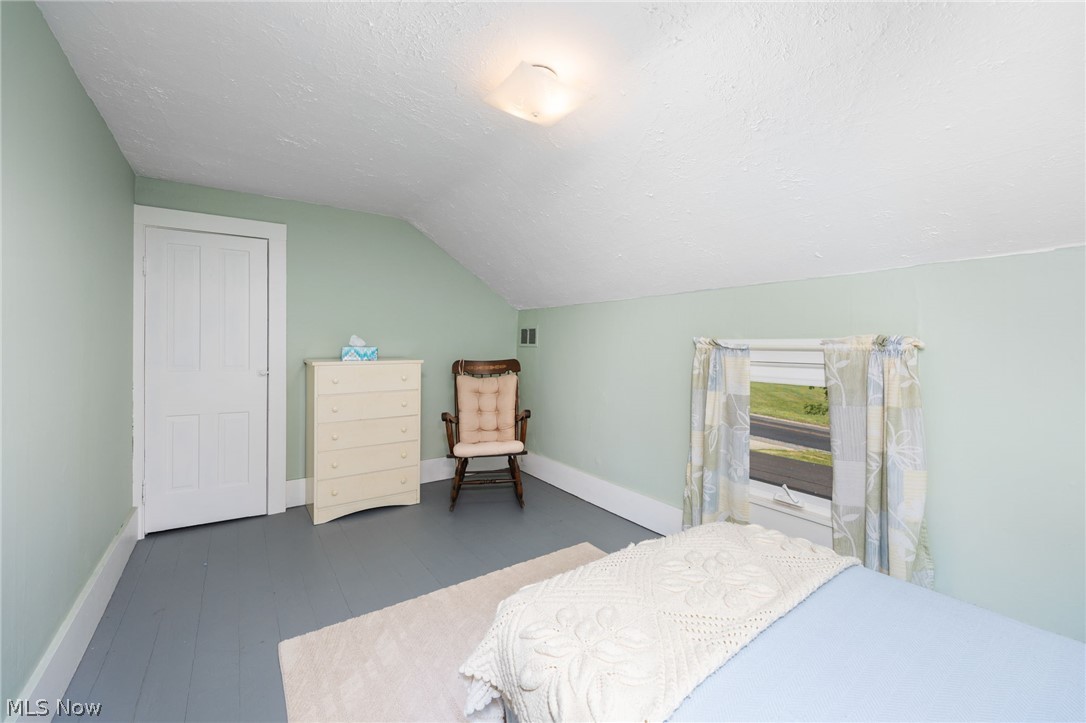 9626 Daniels Road Seville, OH 44273 - Photo 25 of 37 Room featuring light green walls, painted wood-finish flooring, a white paneled door, and a window with blinds and curtains