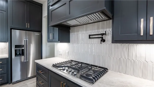 a kitchen with stainless steel appliances granite countertop a sink a stove and a refrigerator