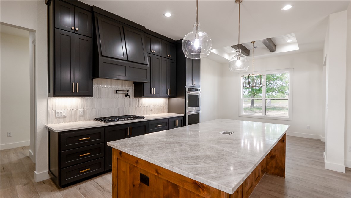 10017 Panther Creek Road Iola, TX 77861 - Photo 14 of 32 a kitchen with stainless steel appliances granite countertop a sink a stove and a wooden floors