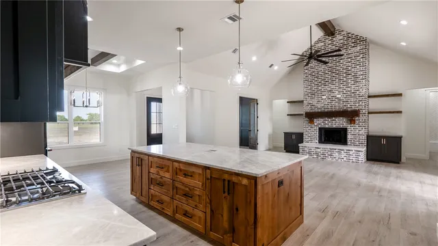 a kitchen with stainless steel appliances granite countertop a sink a stove and a wooden floors