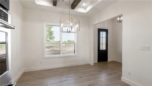 a large kitchen with stainless steel appliances granite countertop a stove and a wooden floor