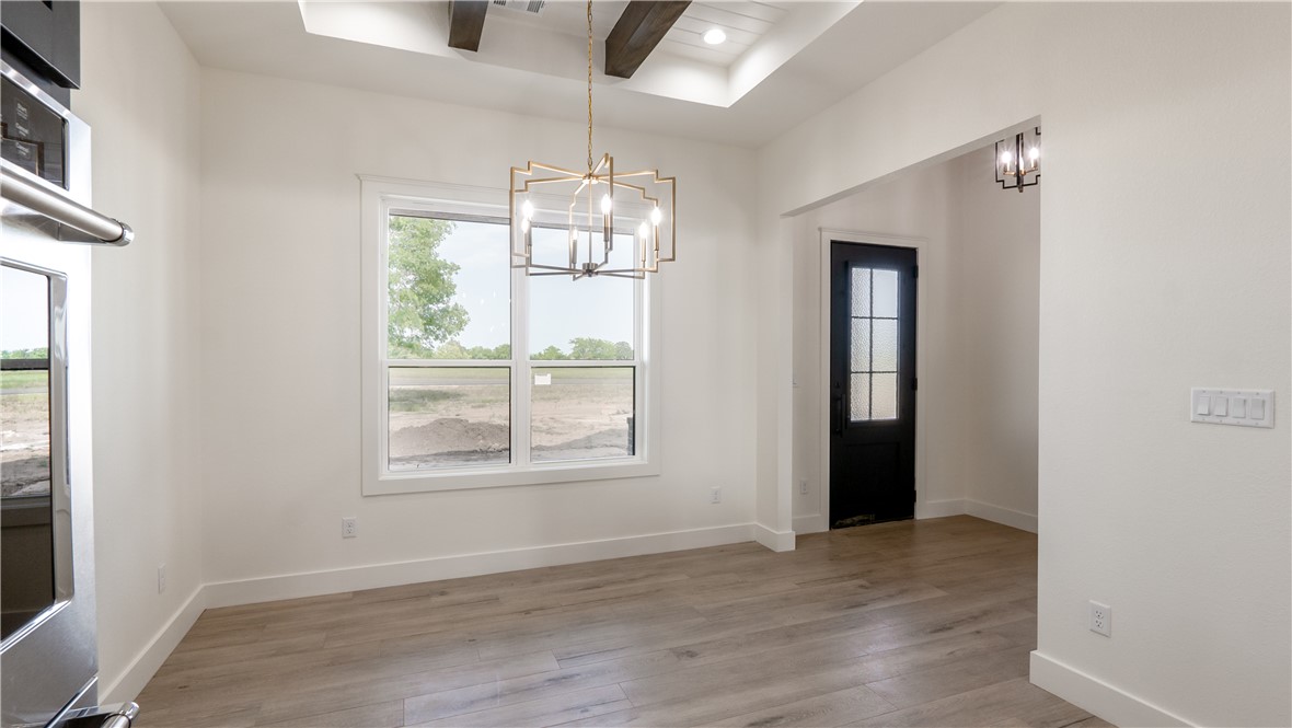 10017 Panther Creek Road Iola, TX 77861 - Photo 16 of 32 an empty room with wooden floor exposed radiator and windows