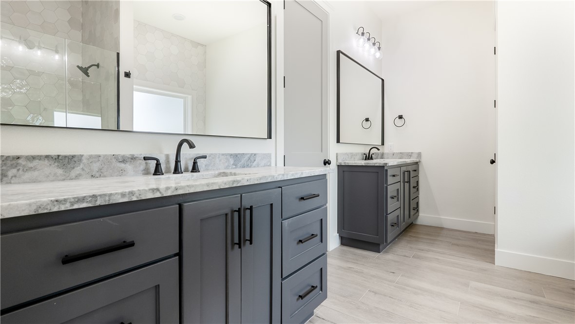 10017 Panther Creek Road Iola, TX 77861 - Photo 19 of 32 a spacious bathroom with a granite countertop sink and a mirror