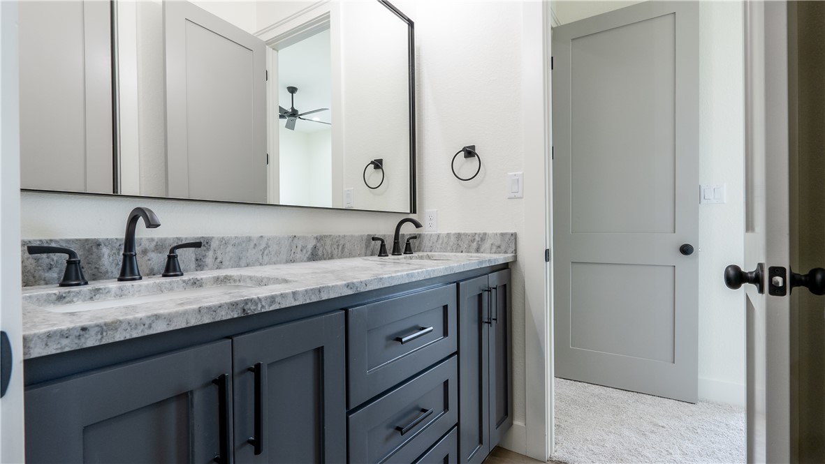 10017 Panther Creek Road Iola, TX 77861 - Photo 22 of 32 a bathroom with a granite countertop sink and a mirror