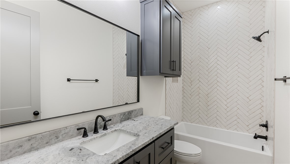 10017 Panther Creek Road Iola, TX 77861 - Photo 25 of 32 a bathroom with a granite countertop sink toilet and shower