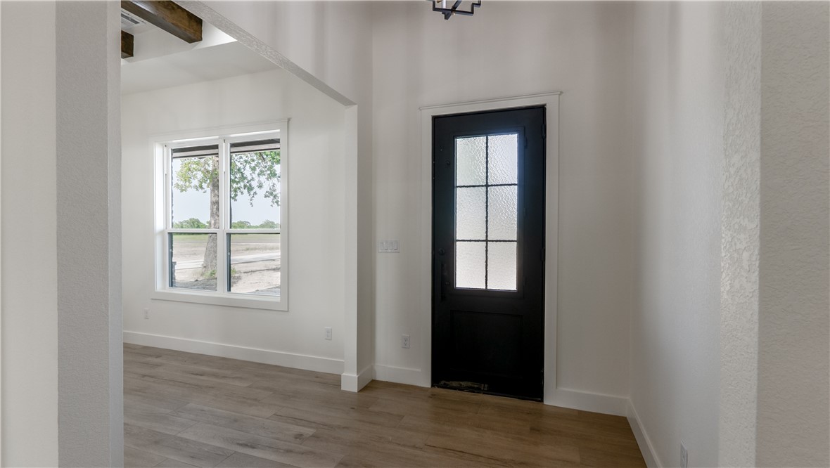 10017 Panther Creek Road Iola, TX 77861 - Photo 3 of 32 an empty room with wooden floor and windows