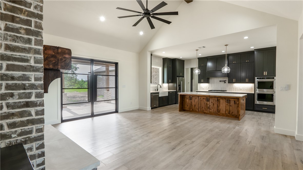 10017 Panther Creek Road Iola, TX 77861 - Photo 5 of 32 a large kitchen with stainless steel appliances a large counter top a stove and a refrigerator