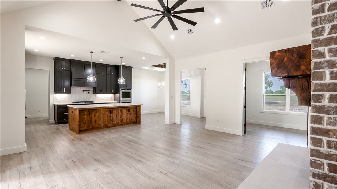 10017 Panther Creek Road Iola, TX 77861 - Photo 31 of 32 a living room with stainless steel appliances kitchen island hardwood floor and a view of kitchen