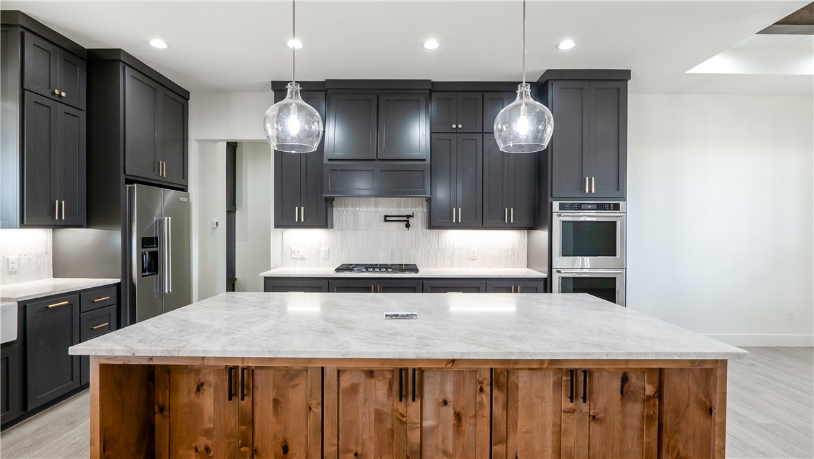 10017 Panther Creek Road Iola, TX 77861 - Photo 9 of 32 a kitchen with stainless steel appliances granite countertop a sink a refrigerator and a stove