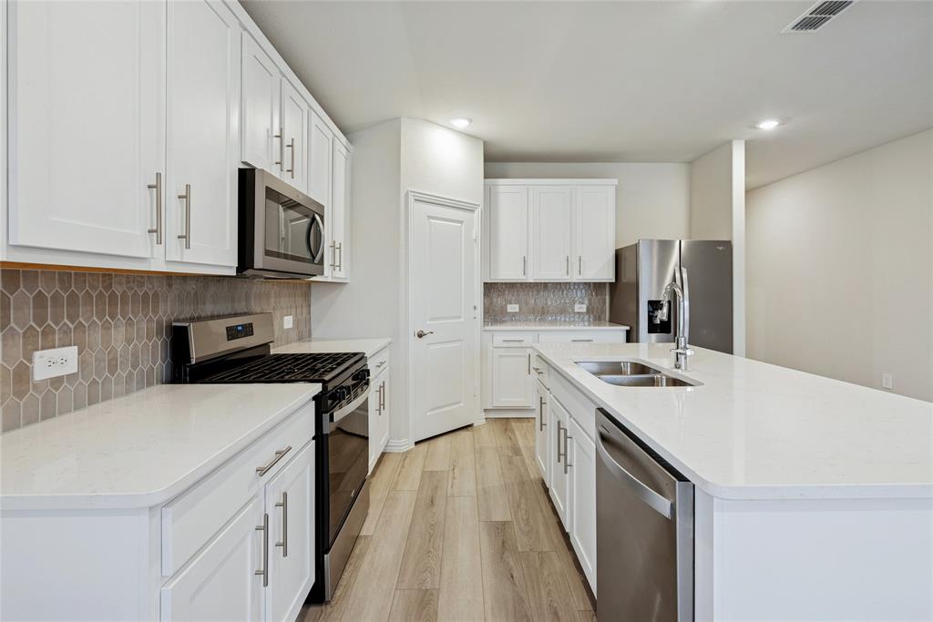 2221 Horseshoe Lane Seagoville, TX 75159 - Photo 5 of 21 a kitchen with a sink a stove and refrigerator