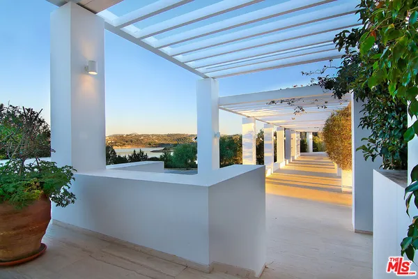 a balcony with furniture and a floor to ceiling window
