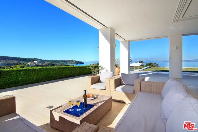 a view of a house with swimming pool and sitting area