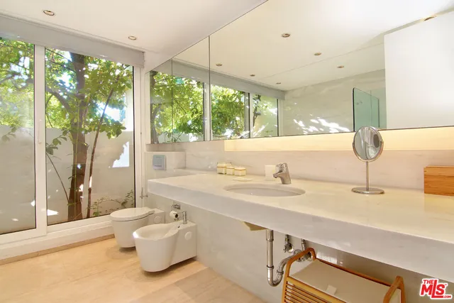 a living room with furniture a flat screen tv and kitchen view