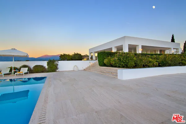 a building outdoor space with patio furniture and a garden