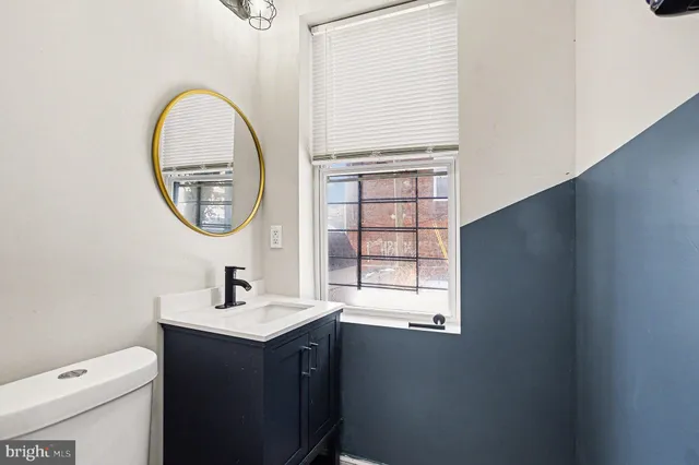 a bathroom with a sink a toilet and a window