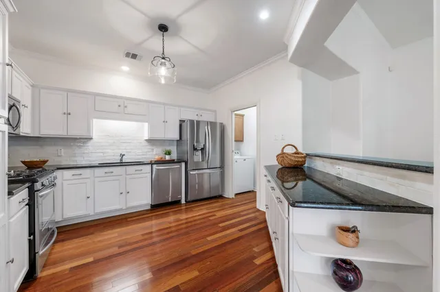 a kitchen with granite countertop a sink appliances and cabinets
