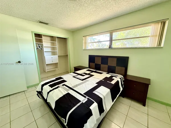a bedroom with a bed and a window