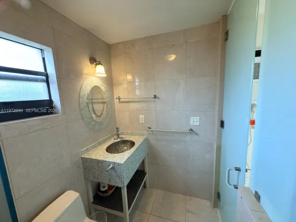 a bathroom with a sink a toilet and a mirror