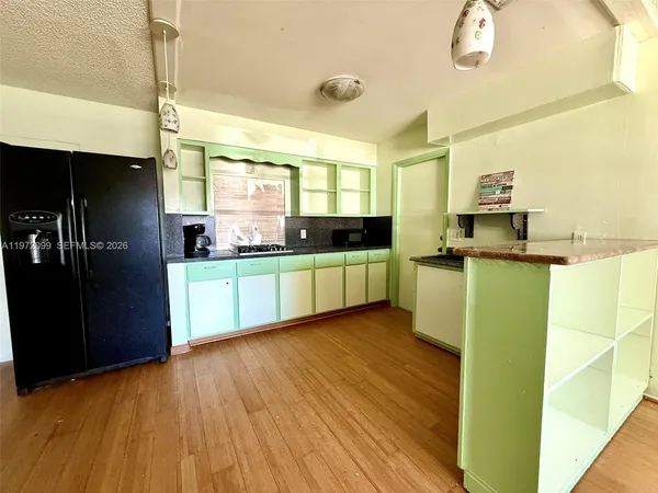 a kitchen with stainless steel appliances wooden floors and wooden cabinets