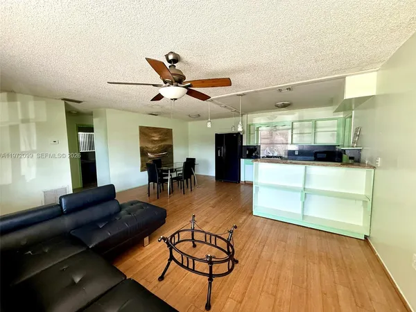 a living room with furniture and kitchen view
