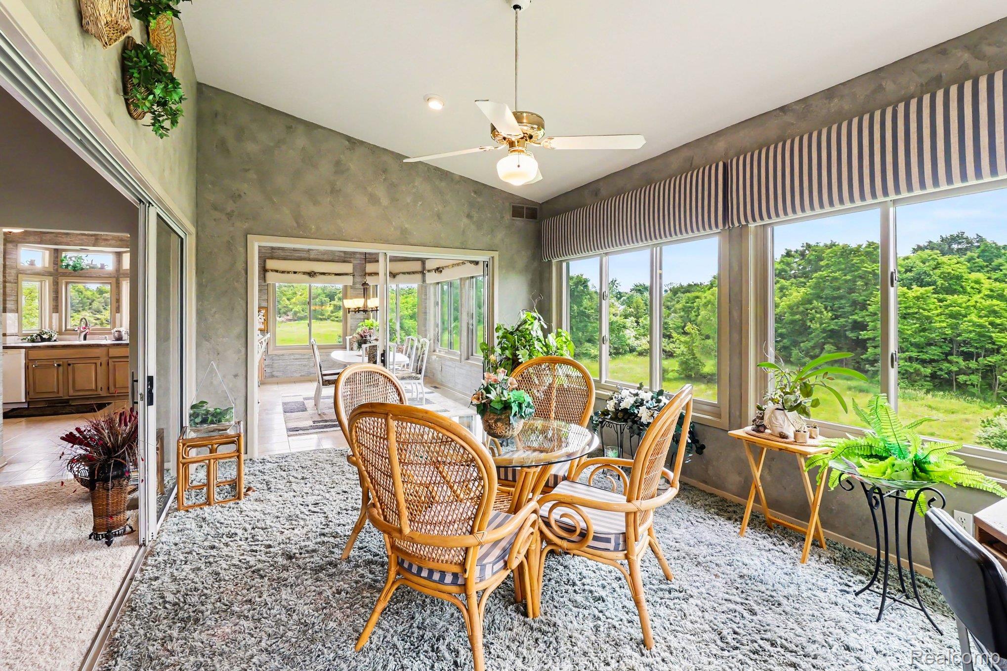 18501 Taylor Lake Road Holly, MI 48442 - Photo 16 of 35 Sunroom featuring expansive windows, vaulted ceiling, and a ceiling fan