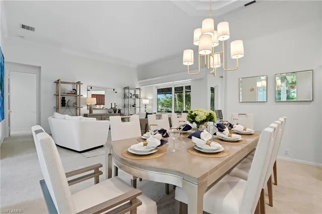 a view of a dining room with furniture a chandelier and wooden floor