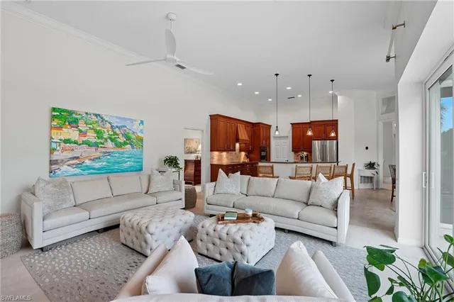 a living room with furniture kitchen view and a potted plant