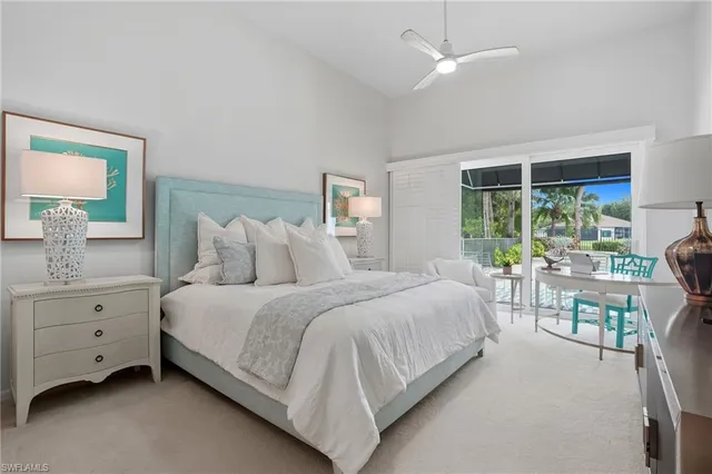 a bedroom with a large bed and a chandelier fan