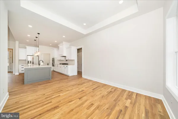 a view of a hallway with wooden floor and a bathroom