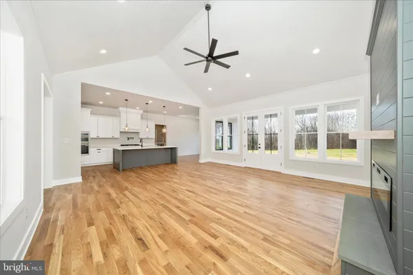 a large kitchen with kitchen island a sink appliances and a counter top space