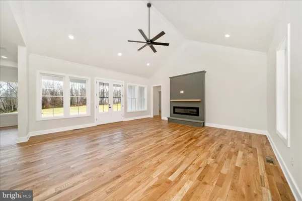 a kitchen with stainless steel appliances a sink a stove a refrigerator a center island and a wooden floor