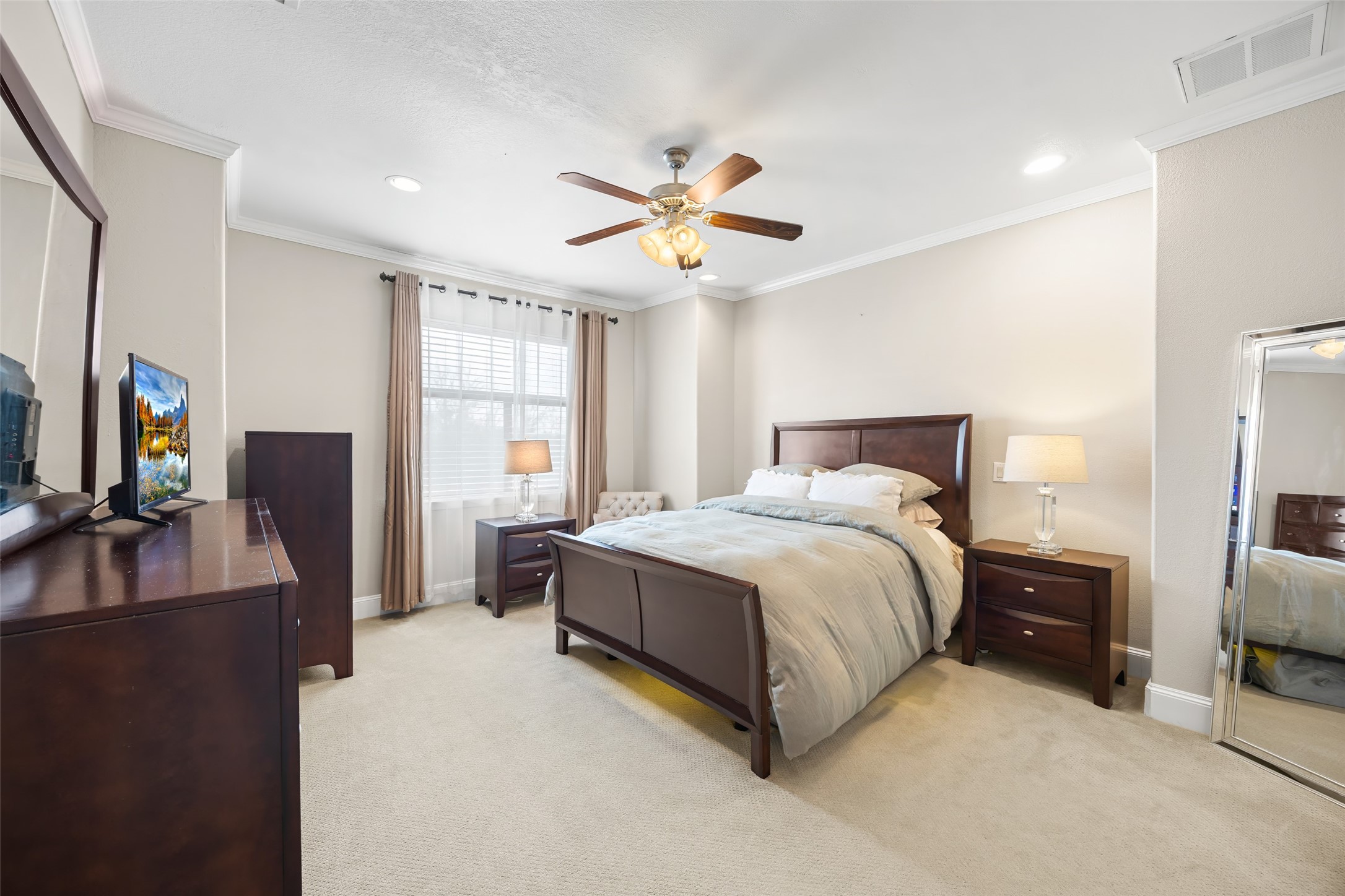 2320 Emancipation Avenue Houston, TX 77004 - Photo 25 of 38 a spacious bedroom with a bed and a flat tv screen on dresser