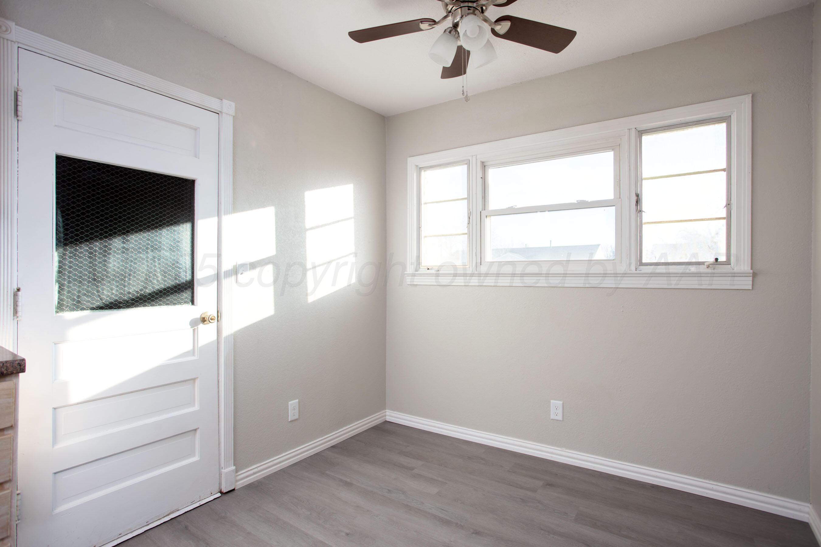 1928 Cherry Street Amarillo, TX 79106 - Photo 3 of 24 a view of an empty room with wooden floor and a window