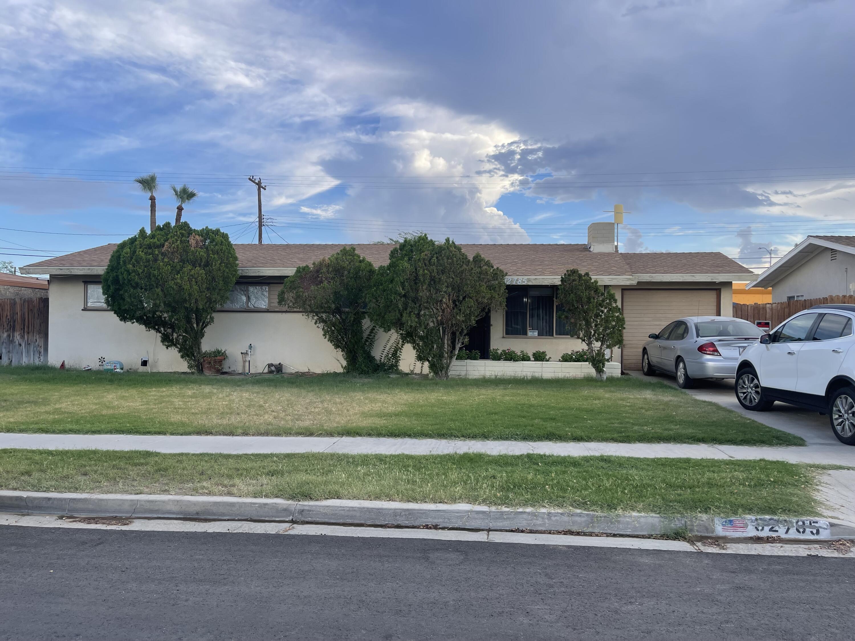 a front view of a house with a garden and plants