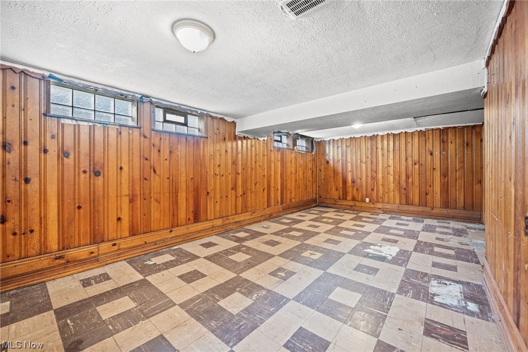 3799 Colony Road South Euclid, OH 44118 - Photo 27 of 34 Basement with a textured ceiling, wood walls, and light tile floors