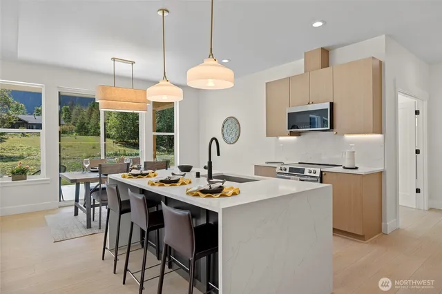 a kitchen with a stove a kitchen island a dining table and chairs
