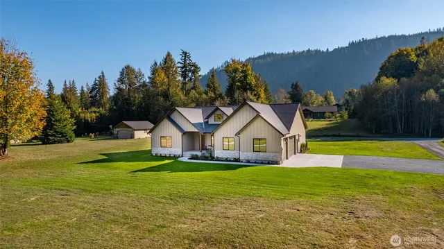 a front view of a house with a big yard and palm trees