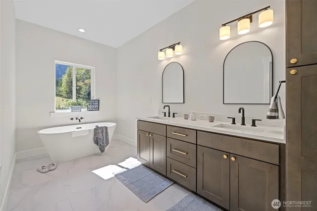 a spacious bathroom with a double vanity sink mirror and bathtub