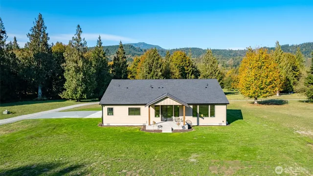 a front view of a house with a garden and trees